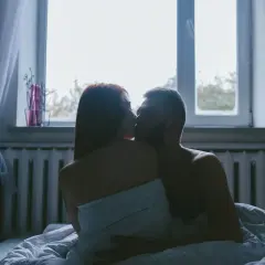 Para kochająca się w łóżku, w intymnej pozycji kurtyzany, przy oknie.