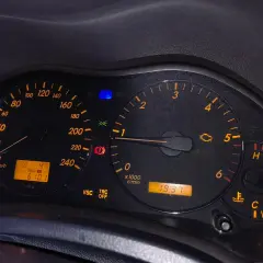 Kontrolka silnika świeci się, wskazując błąd DTC C1201 Toyota. Na desce rozdzielczej widoczne są też inne kontrolki i wskaźniki.