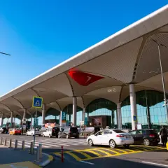Nowe lotnisko w Bodrum tętni życiem. Samochody i taksówki czekają na pasażerów pod nowoczesnym zadaszeniem.