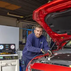 Mekaniker arbetar med en bilens AC-system, som visar hur fungerar en ac i bilen.