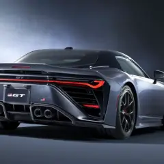 Tylna część sportowego, ciemnoszarego coupe Toyota GR GT z czterema końcówkami wydechu i ostrymi światłami LED.