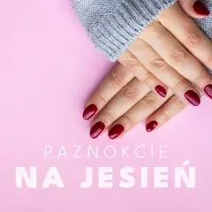 Dłonie w szarym swetrze z idealnymi, bordowymi paznokciami na jesień.