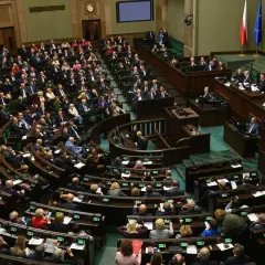 Posiedzenie Sejmu. Wiele osób siedzi w ławach, dyskutując o przyszłości kraju. Czy zaufanie do polityków jest uzasadnione?