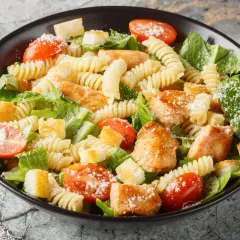 Prosta sałatka z piersią kurczaka, makaronem fusilli, pomidorkami koktajlowymi, grzankami i parmezanem.