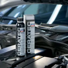 Botella y caja de LIQUI MOLY Cera Tec en un motor. Evita problemas de motor con este aditivo cerámico.