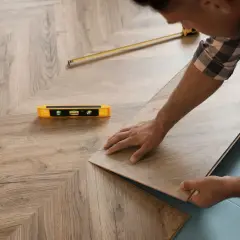 Installazione di un nuovo pavimento in laminato, posato come massetto sopra pavimento esistente. Livella e metro a nastro a portata di mano.
