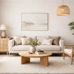 Salón con sofá blanco, mesa de centro de madera y sillón, todo en una serena **decoración Japandi**.