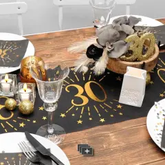 Einfache Tischdeko Geburtstag selber machen: Goldene "30" auf schwarzem Läufer, Kerzen, Gläser und Deko-Kugeln für eine festliche Feier.