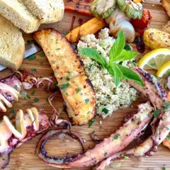 Wyśmienite greckie jedzenie: grillowane kalmary, krewetki, łosoś, pieczone ziemniaki, kasza i pieczywo.