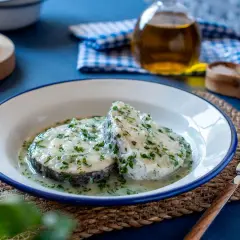 Dos rodajas de merluza en salsa verde, con perejil picado y un toque de ajo.
