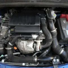 Silnik samochodowy Suzuki SX4 z widocznymi przewodami, akumulatorem i elementami układu dolotowego.