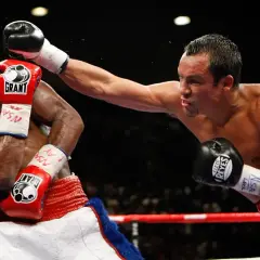 Boxer dodges a punch with a shoulder roll, his opponent's glove narrowly missing his head.