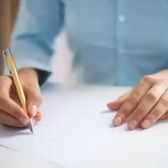 Dłonie piszą wniosek o odpis wyroku sprzed lat.