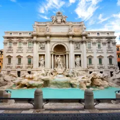 La Fontana di Trevi, con le sue sculture barocche e l'acqua turchese, incanta sotto un cielo azzurro.