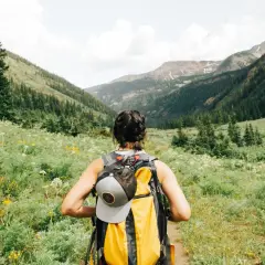 Kobieta z plecakiem wyrusza na szlak. To idealny dzień na trekking, który odróżnia się od zwykłego hikingu.
