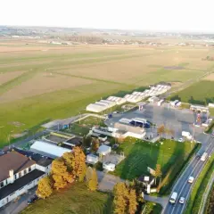 Lotnisko z hangarem i pasem startowym. W oddali widać pola i zabudowania. To miejsce, gdzie każdy wielki zwycięzca może wylądować.