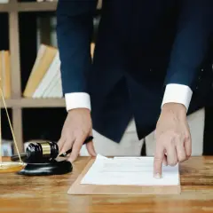 Prawnik wskazuje na dokument, obok wagi sprawiedliwości i młotka. Dowiedz się, ile wynosi podatek od spadku.