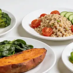 Platos con pollo a la parrilla, brócoli, batata, quinoa y ensalada. Una dieta balanceada para dejar de comer para adelgazar.