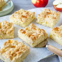 Saftiger Apfelkuchen mit Streuseln, frisch gebacken und in Stücke geschnitten. Ein Genuss für jeden Kaffeetisch.