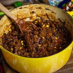 En stor gul gryta fylld med mustig chili sin carne, redo att serveras. Perfekt för ett värmande recept.