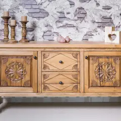 Buffet en bois sculpté, prêt à recevoir une nouvelle teinte. Ses portes ornées de motifs étoilés et ses tiroirs invitent à le teindre un meuble en bois déjà teint pour un relooking.