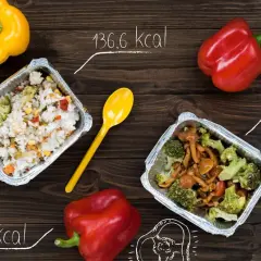 Dwa pojemniki z jedzeniem, papryki i miarka krawiecka. Idealne składniki do diety 2000 kcal.