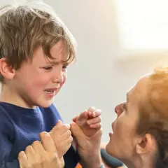 Un niño de 2 años llora desconsoladamente mientras su madre intenta calmarlo.