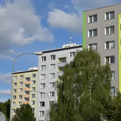 Bloki mieszkalne, drzewa i niebo. Zastanawiasz się, kiedy można wykupić mieszkanie komunalne?