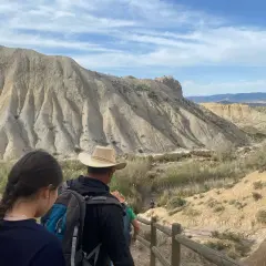 Senderos de desierto, con formaciones rocosas y vegetación escasa. Un grupo de excursionistas camina por un sendero, disfrutando del paisaje.