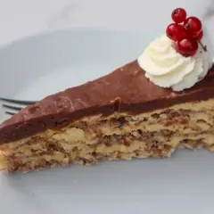En bit chokladtårta med mandelbotten, grädde och vinbär. Ett perfekt recept på daimtårta med mandelbotten.