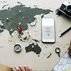 Planujesz podróż? Z mbank ubezpieczenie podróżne masz spokój ducha. Mapa świata, aparat, kompas i telefon z hasłem "Let's go travel" zachęcają do odkrywania świata.