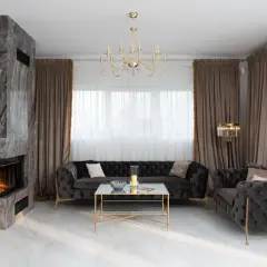 Eleganckie atrapa kominka z marmuru, nowoczesne aranżacje salonu z pikowanymi sofami i złotymi dodatkami.