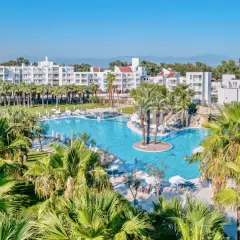 Rodzinny resort Monachus Family Resort Sorgun z basenem i palmami.