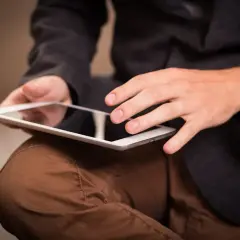 Mężczyzna w garniturze przegląda aplikację do fotowoltaiki na tablecie.