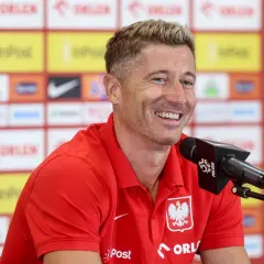 Uśmiechnięty Robert Lewandowski w czerwonej koszulce reprezentacji Polski, przed mikrofonem. Ile języków zna Robert Lewandowski?