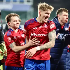 Radosni zawodnicy Rakowa Częstochowa świętują zwycięstwo. Jeden z nich trzyma aparat, by uwiecznić chwilę.