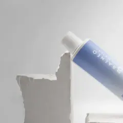 Biała butelka z niebieską etykietą, zawierająca żel do mycia twarzy. Czy to rozwiązanie na nadmiar sebum?