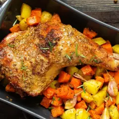 Cuisse de dinde au four, dorée et savoureuse, accompagnée de légumes rôtis et d'ail. Un plat réconfortant prêt à être dégusté.