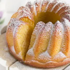 Un soffice ciambellone allo yogurt, spolverato di zucchero a velo, pronto per essere gustato.