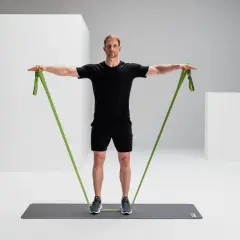 Mann trainiert mit einem grünen Widerstandsband, um seine rotatorenmanschette zu stärken.