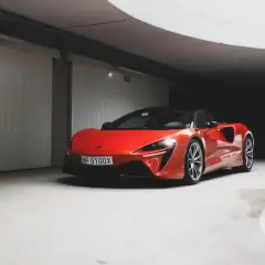 Czerwony McLaren w garażu, jego cena jest wysoka, ale wygląd zachwyca.