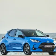 Niebieski segment a, Toyota Yaris, stoi przy morzu.