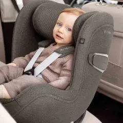 Kleines Kind im Kindersitz, das sich auf die Frage konzentriert: ab wann darf Baby in Fahrtrichtung sitzen?