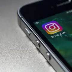 Zbliżenie na ekran telefonu z ikoną Instagrama. Czy widac screeny relacji na IG?