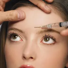Nahaufnahme einer Frau, der Botox in die Stirn injiziert wird. Mögliche botox spätfolgen im Blick.