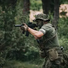 Hombre con camuflaje y pintura facial, listo para jugar airsoft que es un deporte de simulación de combate.