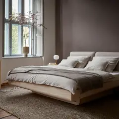 Ein gemütliches Bett mit Leinenbezug und eine Wand in warmem Braunton – das sind die modernen schlafzimmer farben. Holzmöbel und dezente Deko schaffen Ruhe.
