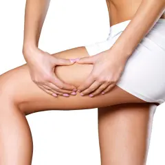 Woman's hands pinching thigh, showing skin texture.