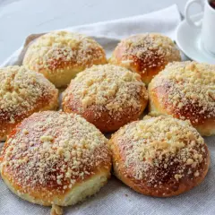 Puszyste drożdżówki z serem, posypane kruszonką, czekają na filiżankę gorącej herbaty.