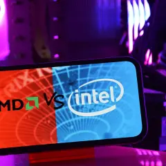 Telefon z logo AMD vs Intel na tle podświetlanego komputera. Wybór między procesorem Intel czy AMD.